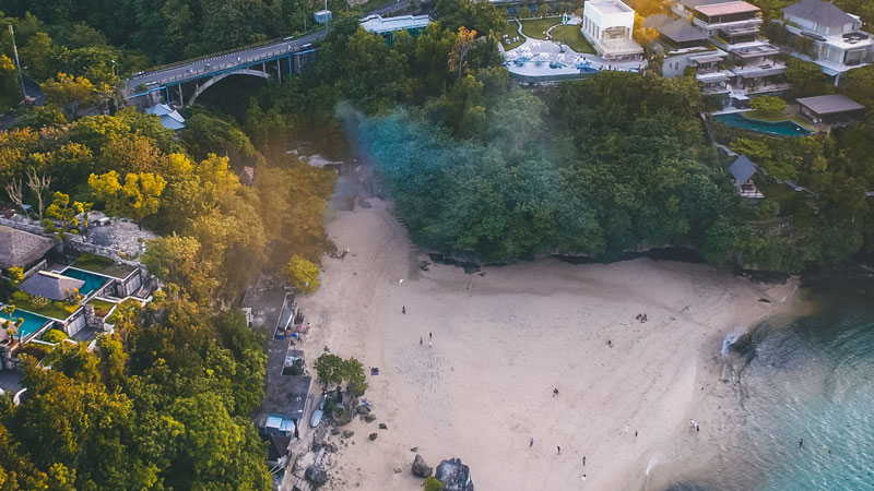 Pemandangan udara Pantai Padang Padang di Bali dengan jembatan dan hutan tropis sekitar