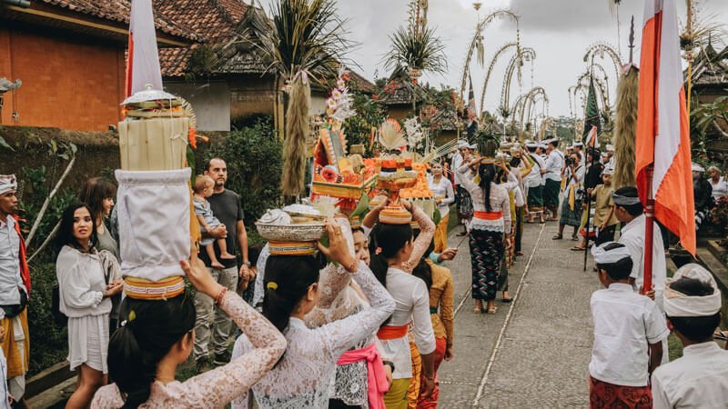 Parade tradisional Bali dengan wanita mengenakan kebaya membawa sesajen