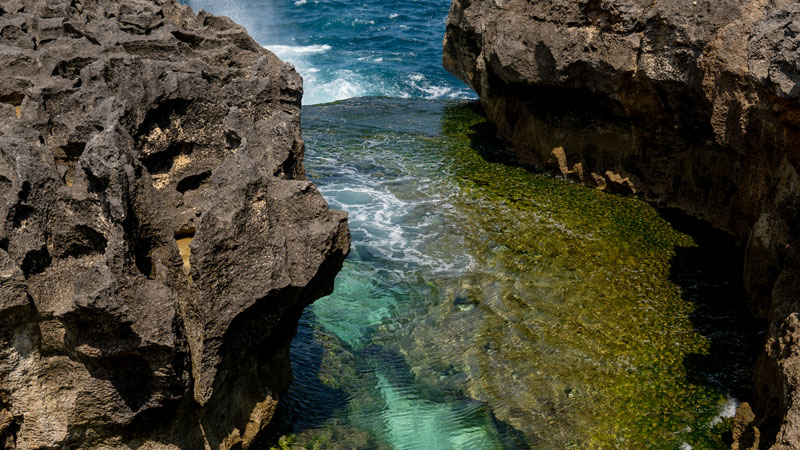 Kolam alami Angel's Billabong dengan air jernih dan karang hijau di Nusa Penida.