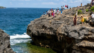 Wisatawan Menikmati Pemandangan di Tebing Pantai Nusa Penida, Bali