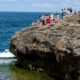 Wisatawan Menikmati Pemandangan di Tebing Pantai Nusa Penida, Bali