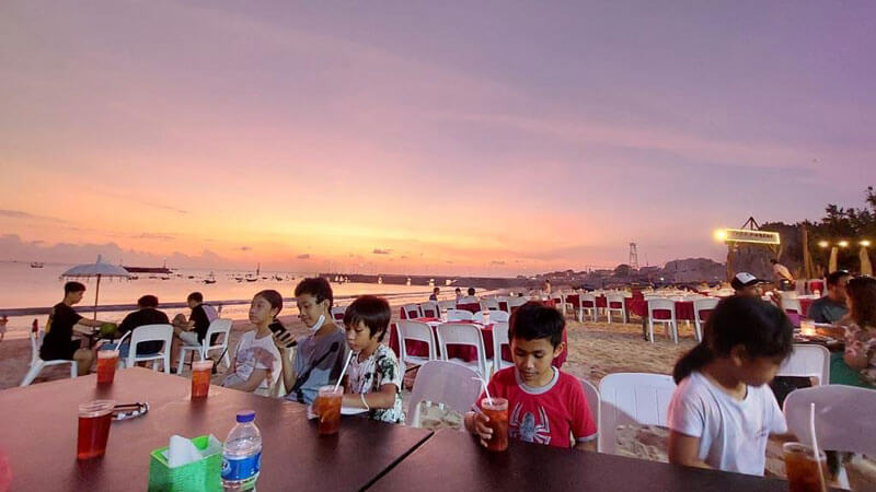 Suasana makan malam di kafe seafood bakar di Pantai Jimbaran