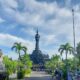 Monumen Bajra Sandhi di Denpasar dengan langit biru cerah, menggambarkan arsitektur khas Bali dan simbol perjuangan kemerdekaan Indonesia