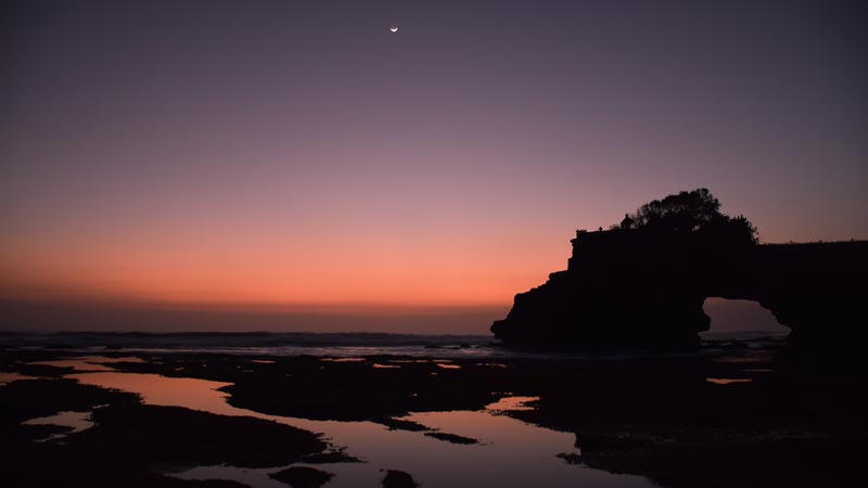 Pura Tanah Lot dengan matahari terbenam yang memukau di latar belakang