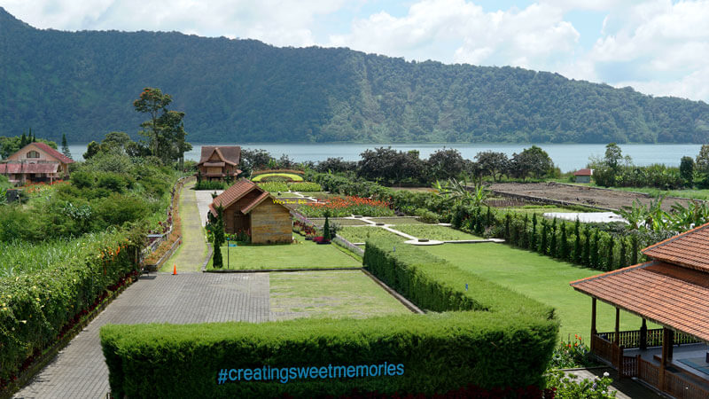 Pemandangan indah taman berlandskap dengan latar belakang Danau Beratan dan pegunungan di Bedugul.