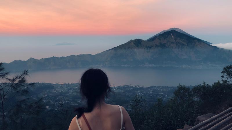 Wanita menikmati matahari terbit di Gunung Batur Kintamani