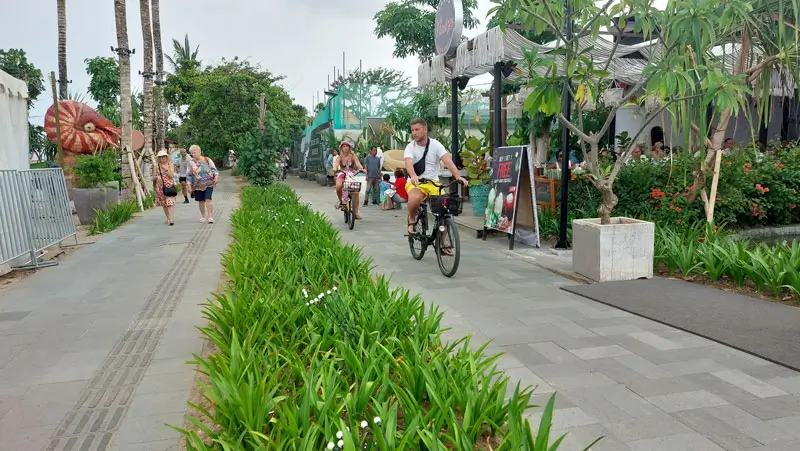 Bersepeda di promenade Tempat Wisata Sanur dengan jalur hijau yang nyaman.