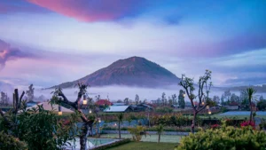Pemandangan indah Gunung Batur di Kintamani dengan kabut pagi dan desa di kaki gunung.
