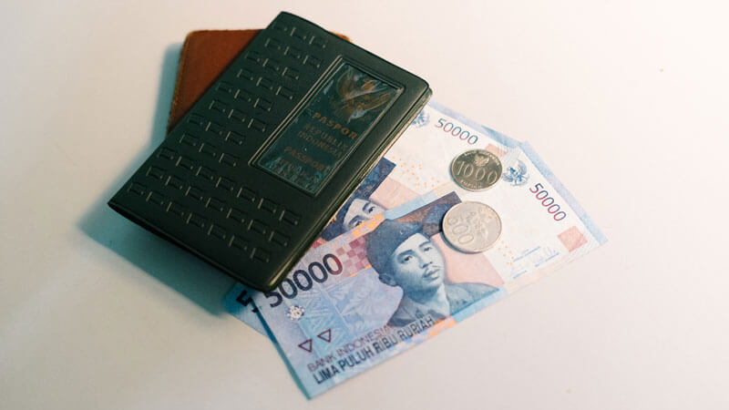 Dompet dengan paspor dan uang Rupiah Indonesia, persiapan untuk membayar tiket masuk destinasi Labuhan Sait