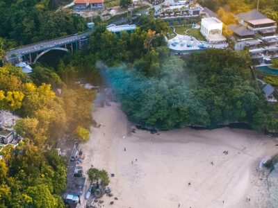 Pemandangan udara Pantai Padang Padang di Bali dengan jembatan dan hutan tropis sekitar