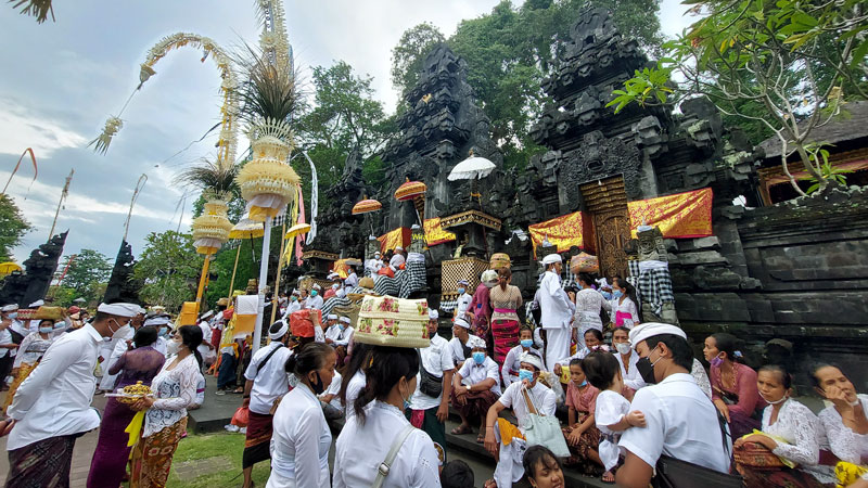 Pengunjung menghadiri upacara di Pura Goa Lawah di Bali