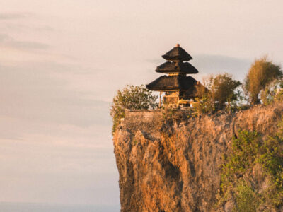 Pura Luhur Uluwatu yang megah berdiri di atas tebing tinggi dengan latar belakang langit senja di Bali.