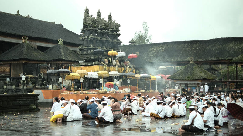 Umat Hindu Bali berdoa bersama di Pura Besakih dengan asap dupa mengepul di latar