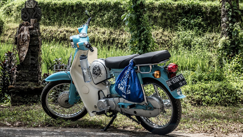 Sepeda motor klasik berwarna biru terparkir siap untuk petualangan di Bali