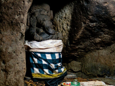 Patung Dewa Ganesha berpakaian upacara di dalam Goa Gajah, Bali