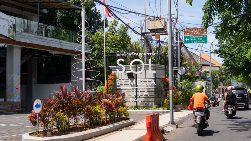 Jalan menuju Pantai Kuta di Bali dengan rambu penunjuk arah dan sepeda motor