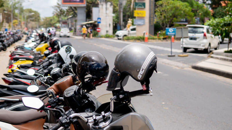 Barisan sepeda motor parkir di tepi jalan dekat Pantai Kuta, Bali