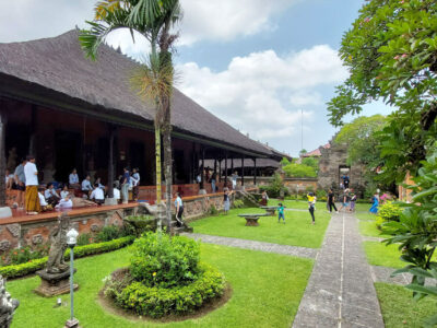 Pemandangan halaman Museum Bali dengan pengunjung dan arsitektur tradisional.