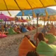 Payung warna-warni dan suasana santai di Pantai Seminyak saat sunset.