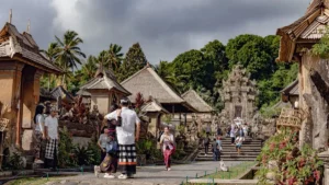 Wisatawan menikmati suasana tradisional dan arsitektur unik Desa Penglipuran Bali di jalan utama desa.