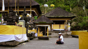 Umat Hindu berdoa di area utama Pura Tirta Empul, dikelilingi oleh arsitektur khas Bali yang suci dan sakral.