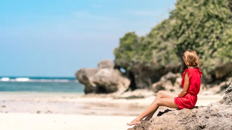 Pantai Dreamland Pecatu dengan tebing batu dan pasir cerah, suasana santai sore