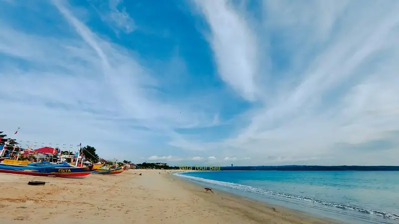 Pantai Jimbaran dengan perahu nelayan dan garis pantai tenang untuk sunset