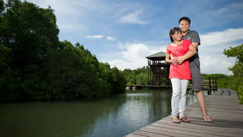Pasangan berfoto di boardwalk kayu Hutan Mangrove Tahura Ngurah Rai Denpasar Bali