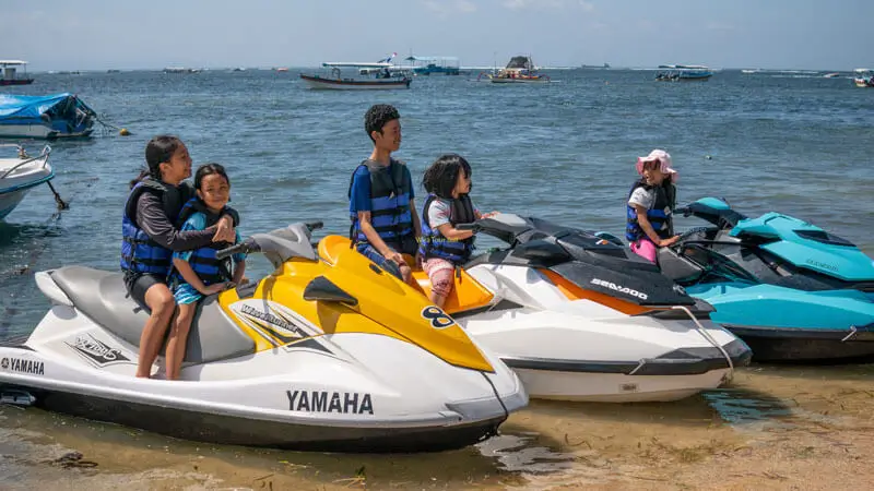 Keluarga mencoba jet ski dengan pemandu di Tanjung Benoa, Bali