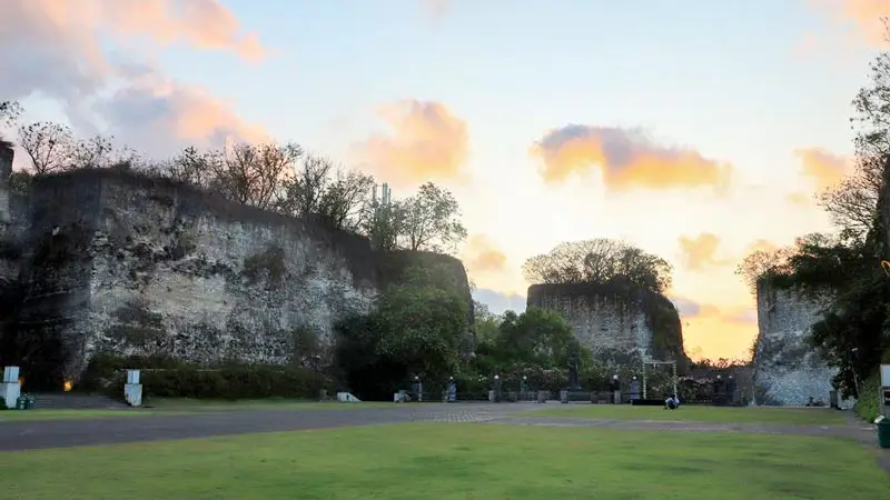Area rumput luas dan tebing batu menjelang sunset di Garuda Wisnu Kencana.
