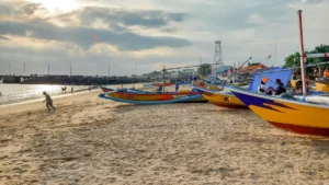Perahu nelayan berwarna di tepi Pantai Kedonganan saat sore
