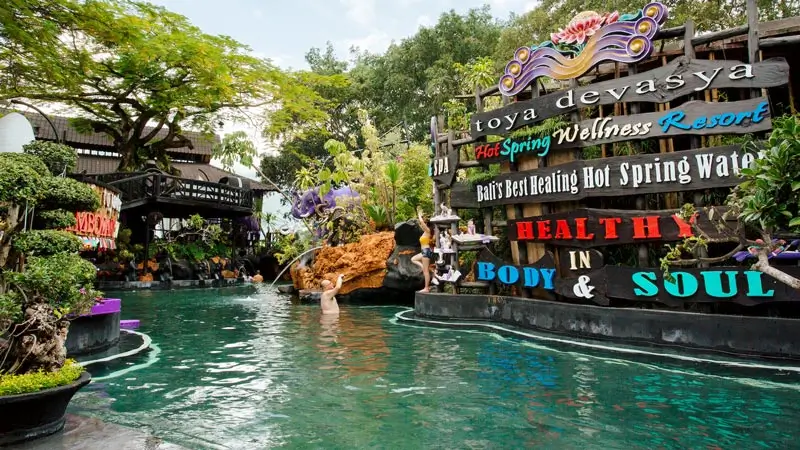 Papan nama Toya Devasya Hot Spring Wellness Resort di area kolam