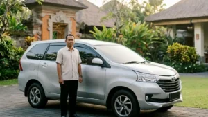 Sopir rapi di samping mobil, ilustrasi ketentuan sewa mobil dengan sopir di Bali.