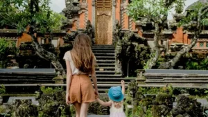 Keluarga berjalan di area pura sebagai pilihan tempat wisata di Ubud
