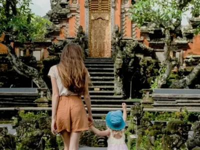 Keluarga berjalan di area pura sebagai pilihan tempat wisata di Ubud