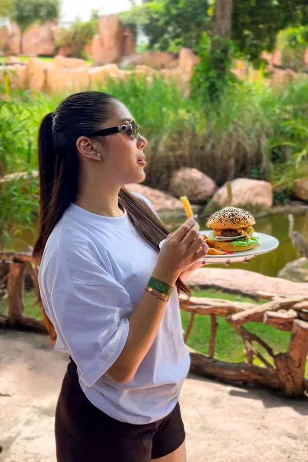 Pengunjung membawa burger untuk makan siang paket Zoo Explorer